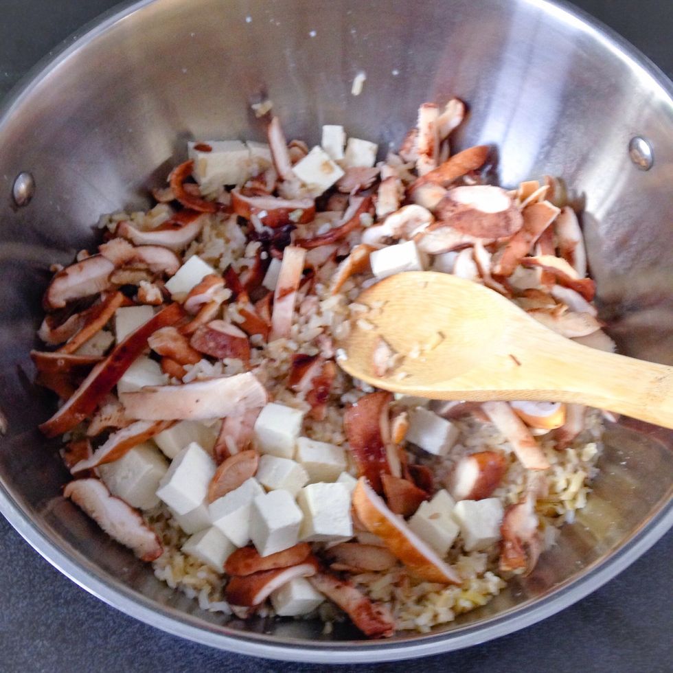 Once rice is cooked and there is only a small amount of moisture left, keep the heat on low and stir in the tofu and mushrooms. Cover and let sit for 10 minutes, stirring occasionally.