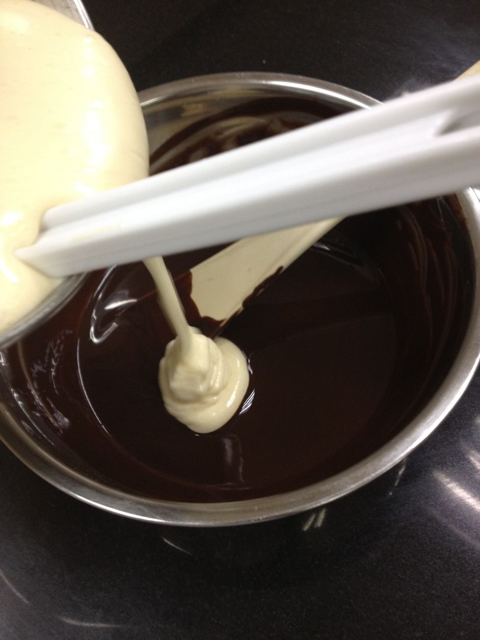 Once that's done, pour half of the egg, sugar and flour batter into the melted chocolate and butter.