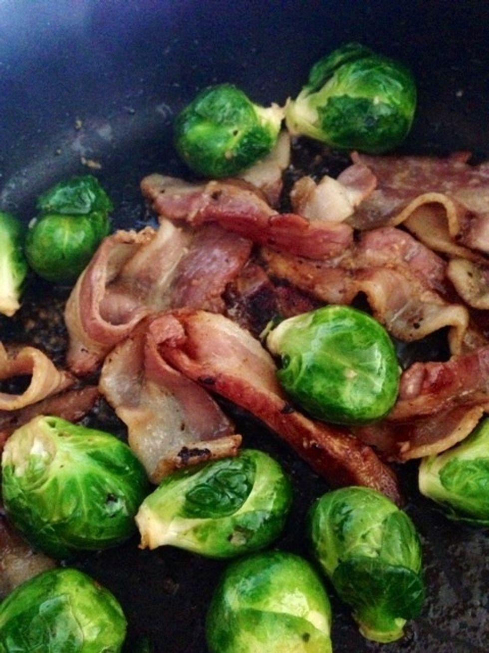 Once the bacon is about half of the way cooked, add your brussels sprouts in. Squeeze the second lemon over the bacon and brussels sprouts.