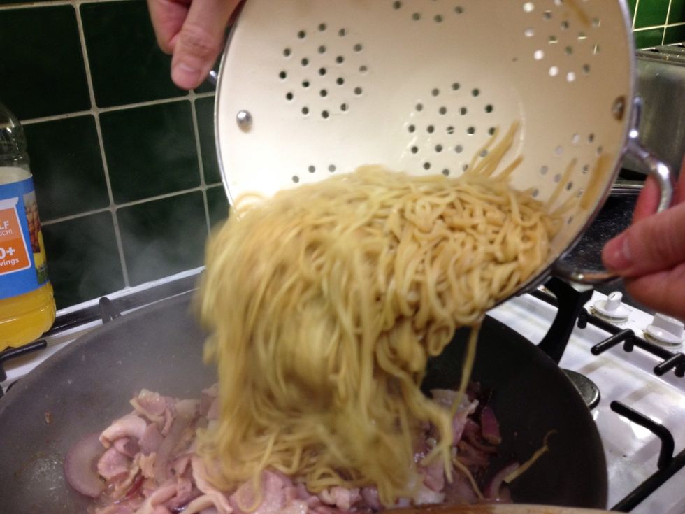 Once the bacon is cooked to how you want it (crispy, blackened etc) then drain the noodles and add to the wok