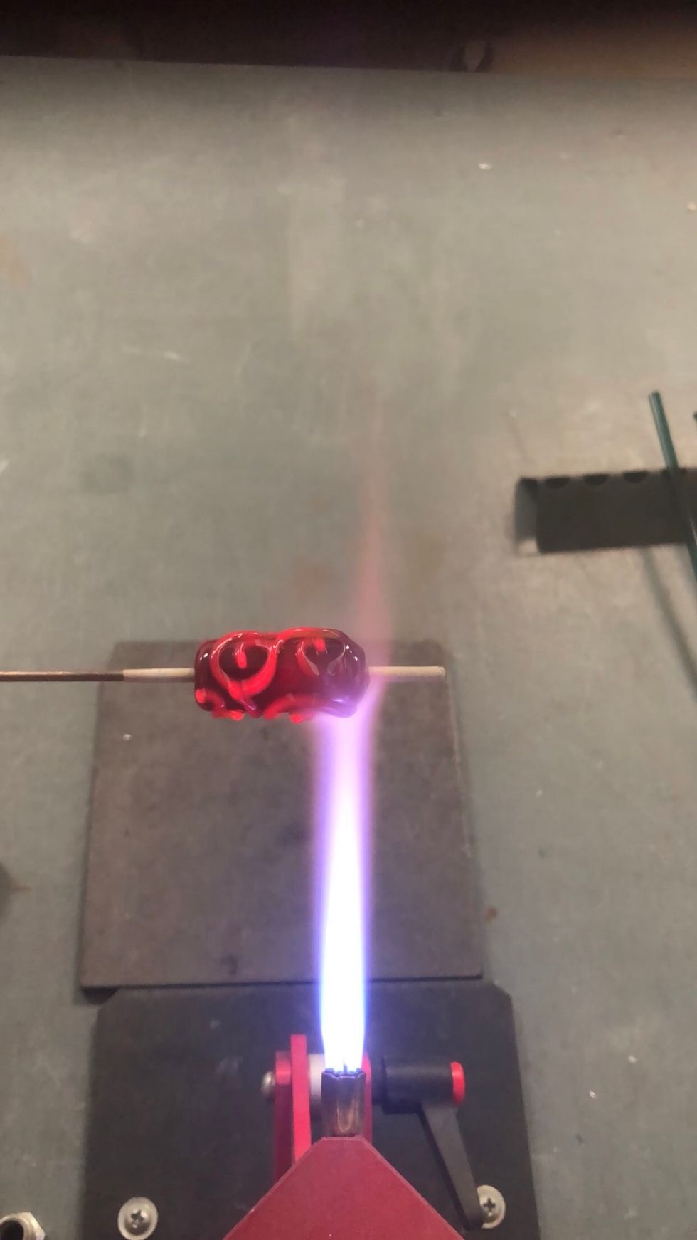 Once the bead is covered in enough spiraling curlicues, give the whole bead a gentle heating. This will weld the scrollwork to the base bead and heat the core enough to avoid cracking.