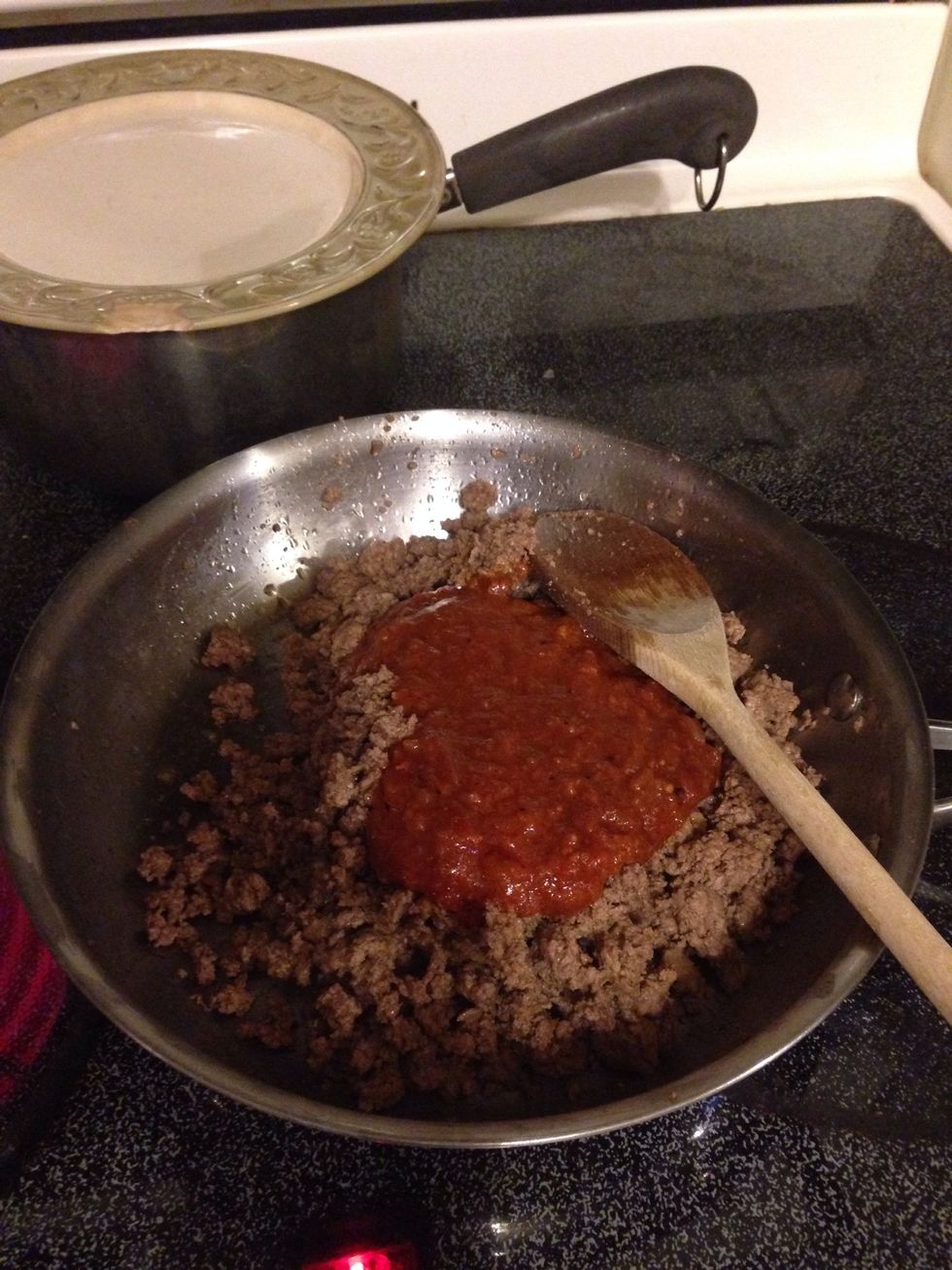 Once the beef is cooked strain the fat from the pan and add the taco seasoning to the beef.