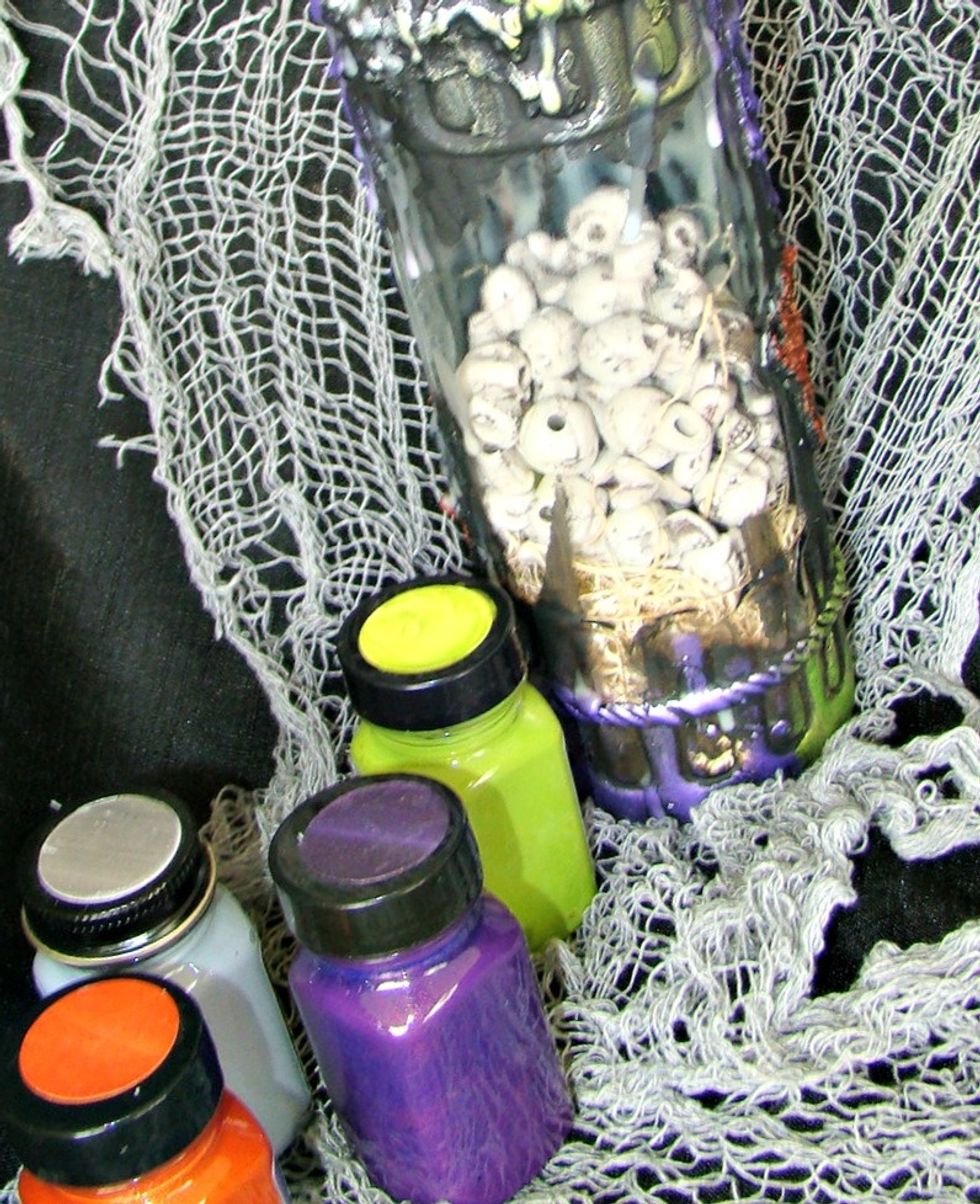 Once the black paint is dry, using your Art Anthology paints, dry brush them over the top of the wax to highlight areas of the bottle.