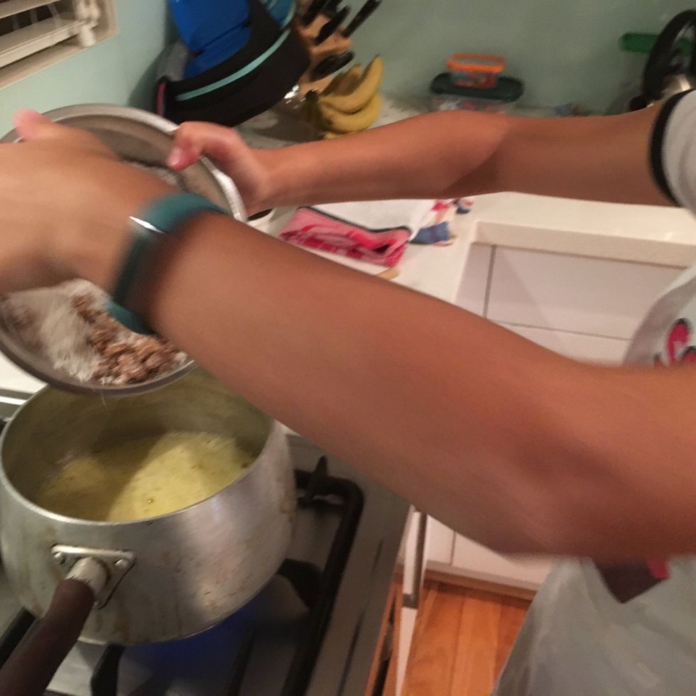 Once the butter has melted add the coconut and brown sugar to the butter and mix.