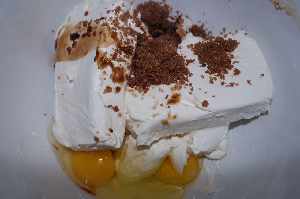 Once the cheeses are cooled to room temperature, you put the three cheeses into the bowl to mix. You also crack the three eggs. Next you'll add the 1 tsp of vanilla & 1c of sugar.