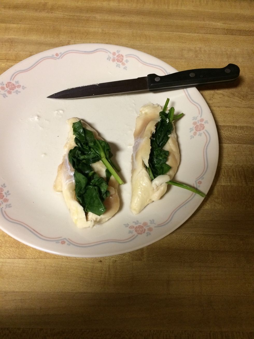 Once the chicken is cut, put the wilted spinach in the cuts you made in the chicken. Try to evenly spread out the spinach. I like a lot of spinach in mine.