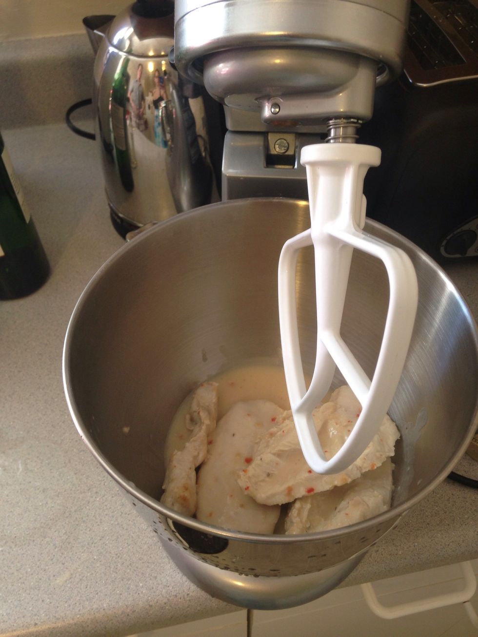 Once the chicken is done, it's time to shred the chicken. You. Can manually do it, but the kitchen aid works really well for this.