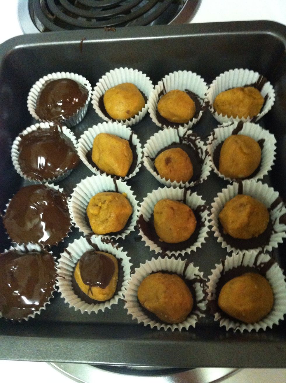 Once the chocolate is cooled place a peanut butter disk on top of each, placing it as close the the middle as you can, leaving as much room for the chocolate to go on top as possible.