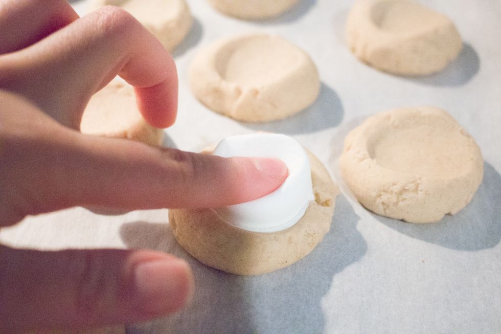 Once the cookies are done, place your one marshmallow inside each cookie well.