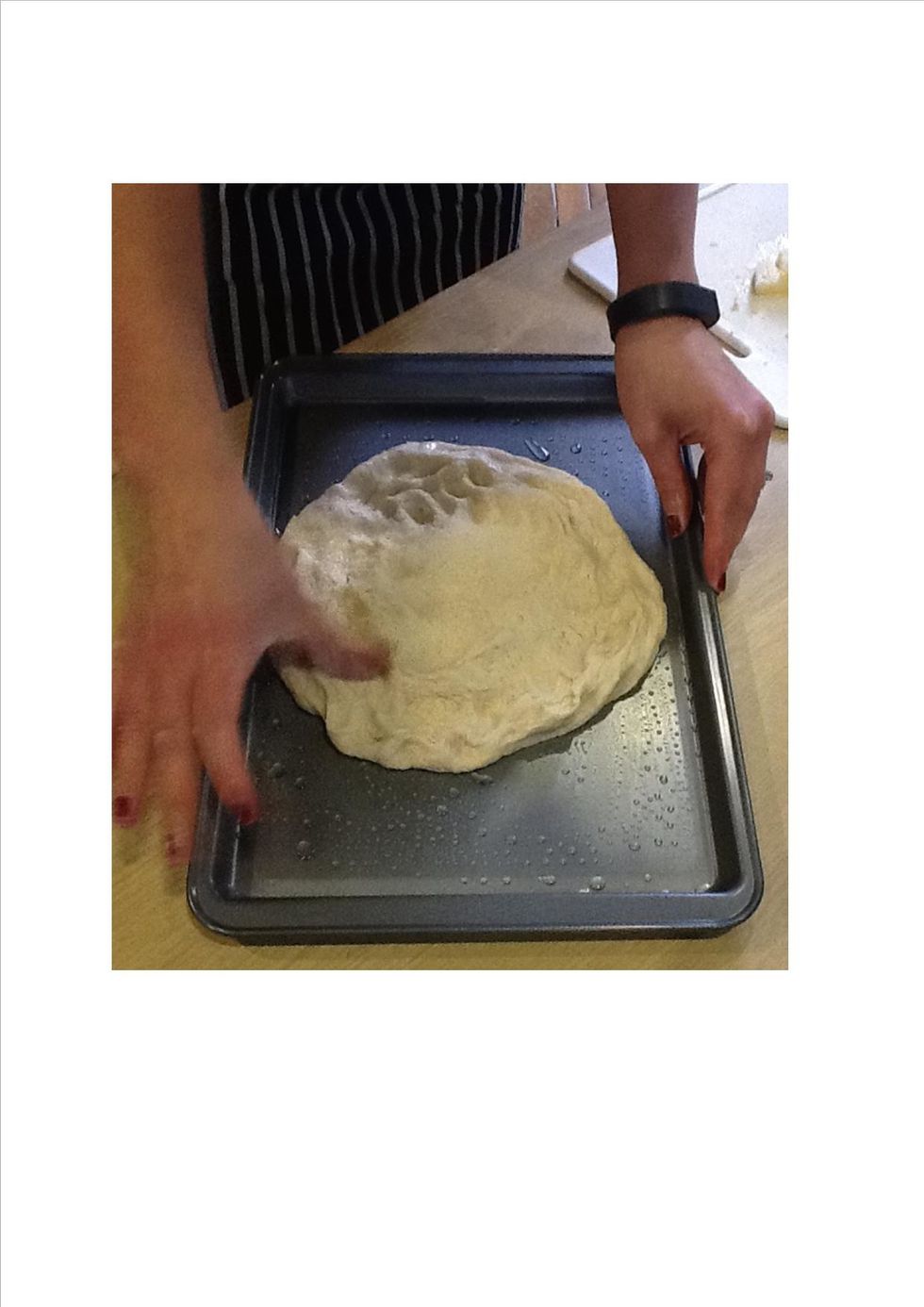 Once the dough has proved, place the dough into a pizza or baking tray.
