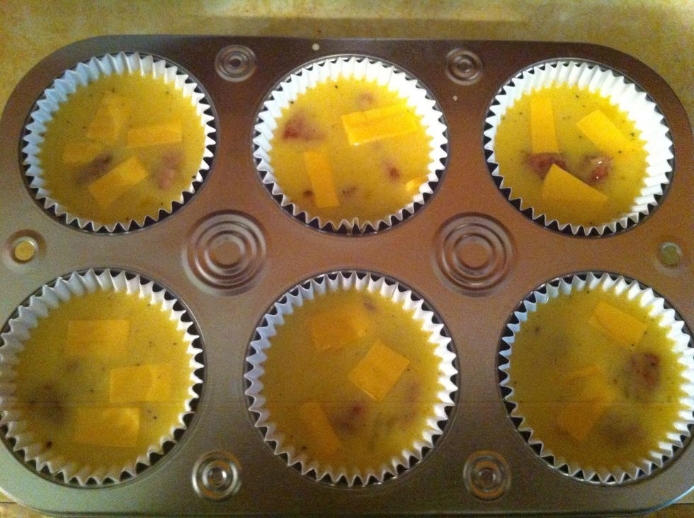 Once the eggs are in the cupcake sheets, add cheese. I prefer doing it this way. Otherwise the cheese settles at the bottom of the bowl.