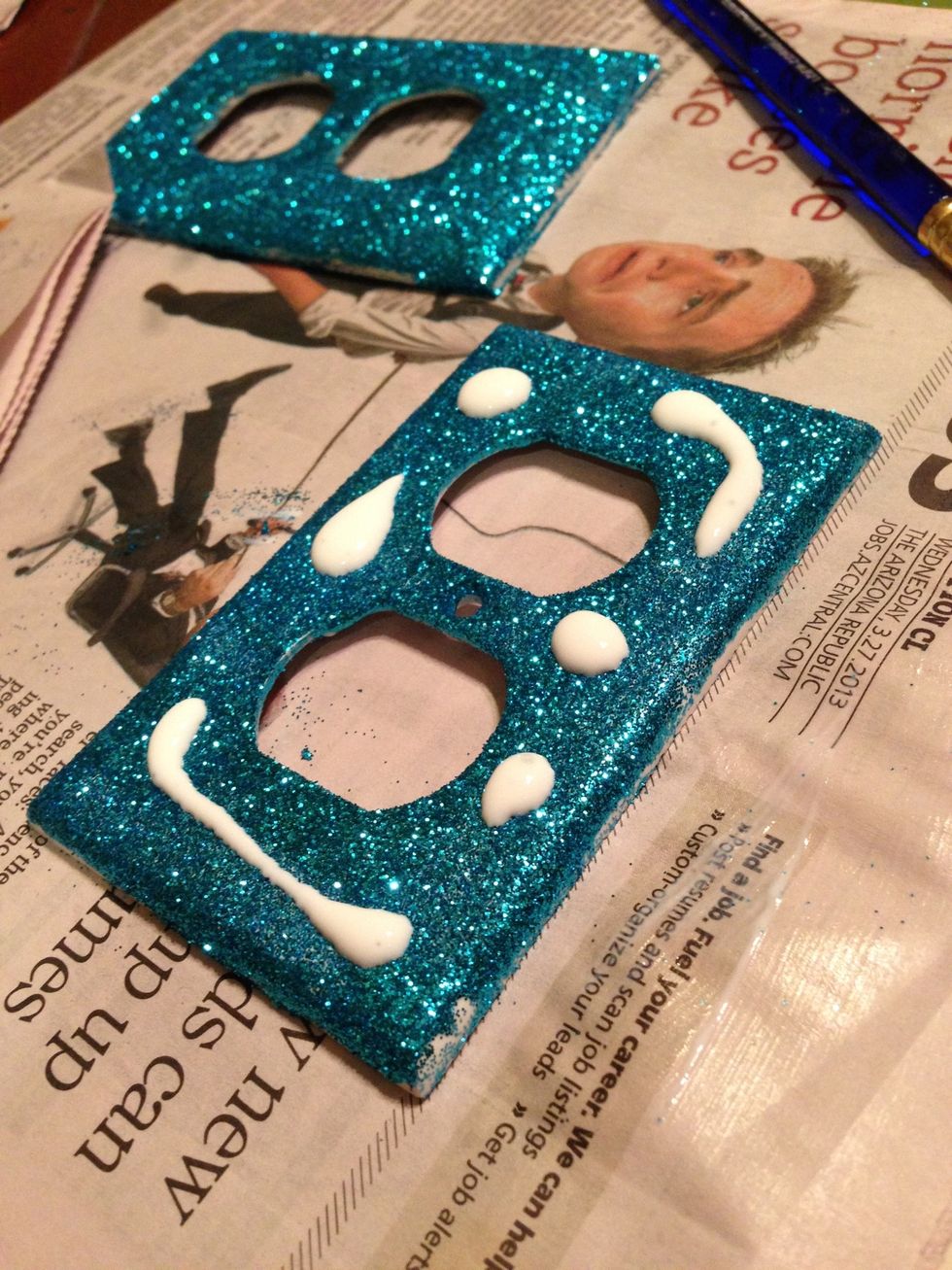 Once the excess glitter is gone, put a couple drops of modge podge on top of the outlet cover or switch plate