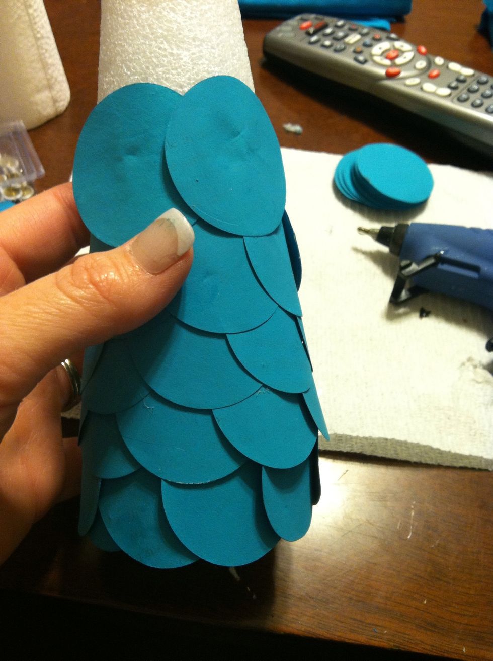 Once the first row is complete, the new row should start in the middle of two circles. Doing this gives the tree a scalloped look and offers definition to the tree.