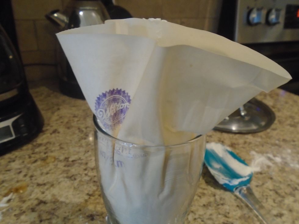 Once the frosting is in the bag, unfold the bag from the sides of the glass.