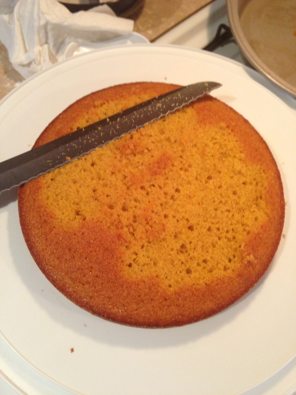 Once the frosting is made it is time to assemble the three layers of cake. Carve the surface of the 1st layer so it is flat with a long bread knife.
