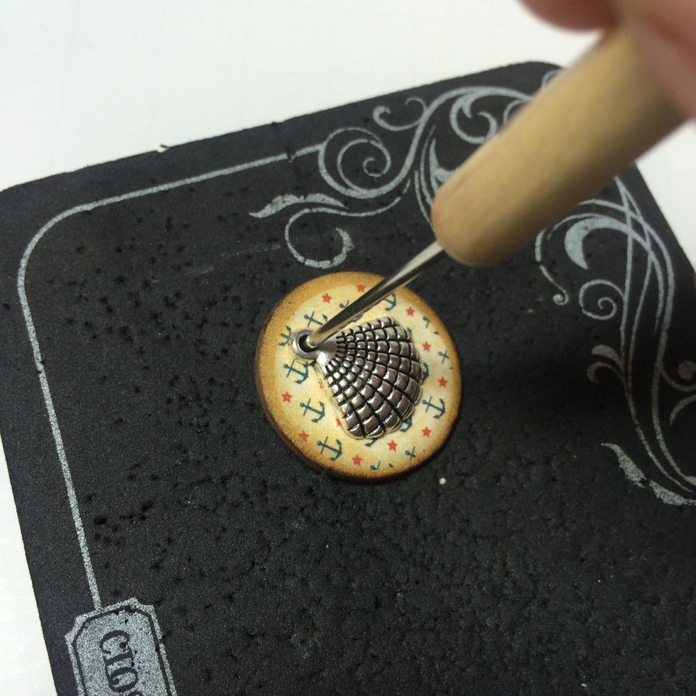 Once the glue is dry, pierce a hole through the chipboard where the charm opening is.