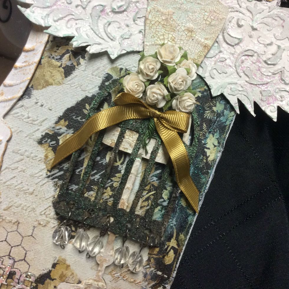 Once the graphite paste is dried I gave it many sprays of Treasure Island Turquoise spray and added my gems to the bottom and embellished with mini roses and ribbon.