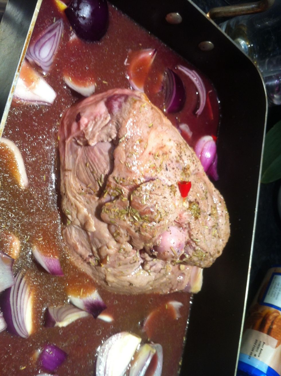 Once the meat has been browned - add the chopped onions , red wine and rosemary to a roasting dish