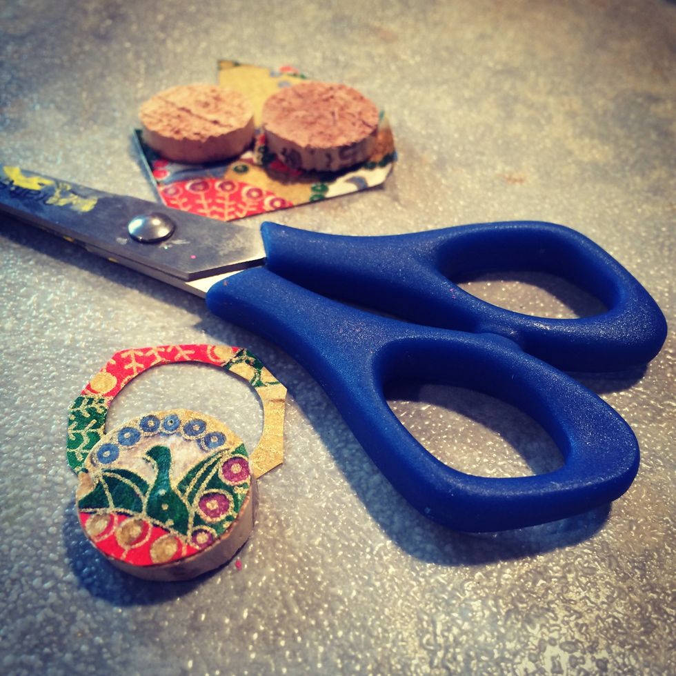 Once the Mod Podge is dry trim the excess paper from your cork. Cut along the edge of the cork so the edge of the glued paper is in line with the edge of the cork.