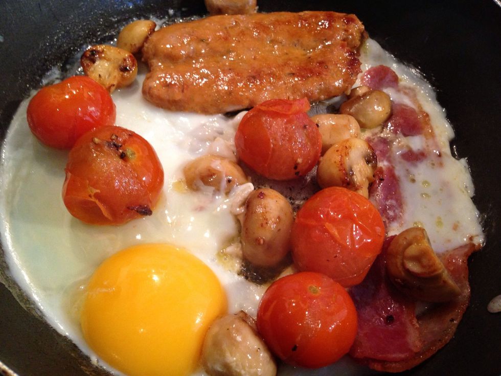 Once the mushrooms and tomatoes are cooked to your liking spread everything around evenly and crack the egg into the pan and tilt it so that the white covers everything
