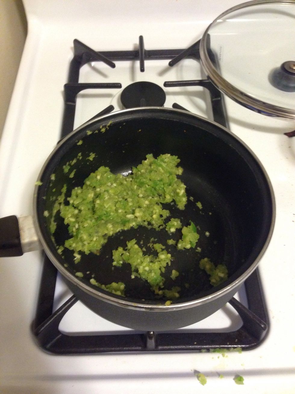 Once the oil is high, add the minced onion and pepper mixture.