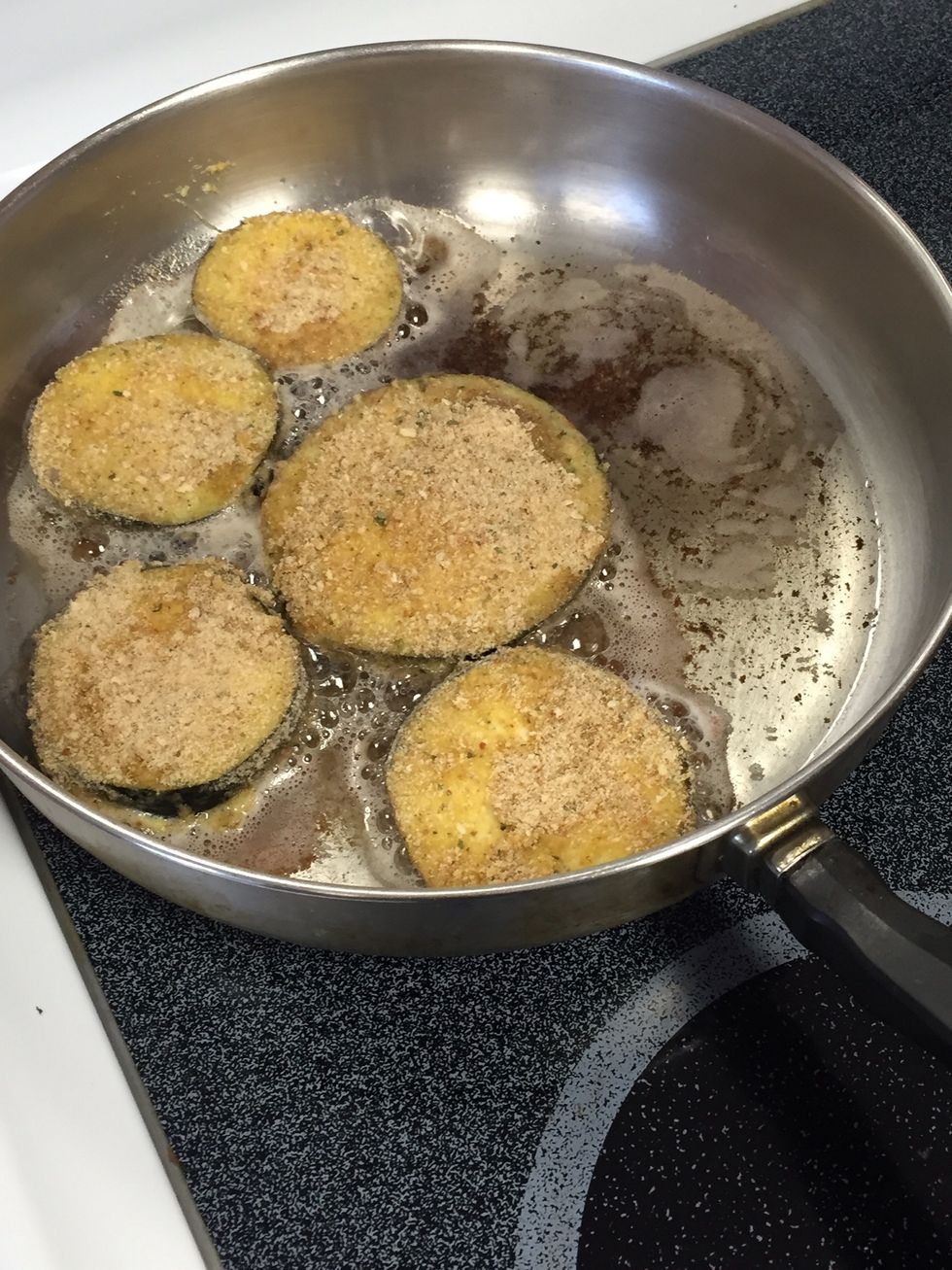 Once the oil is hot add the breaded eggplant into the pan