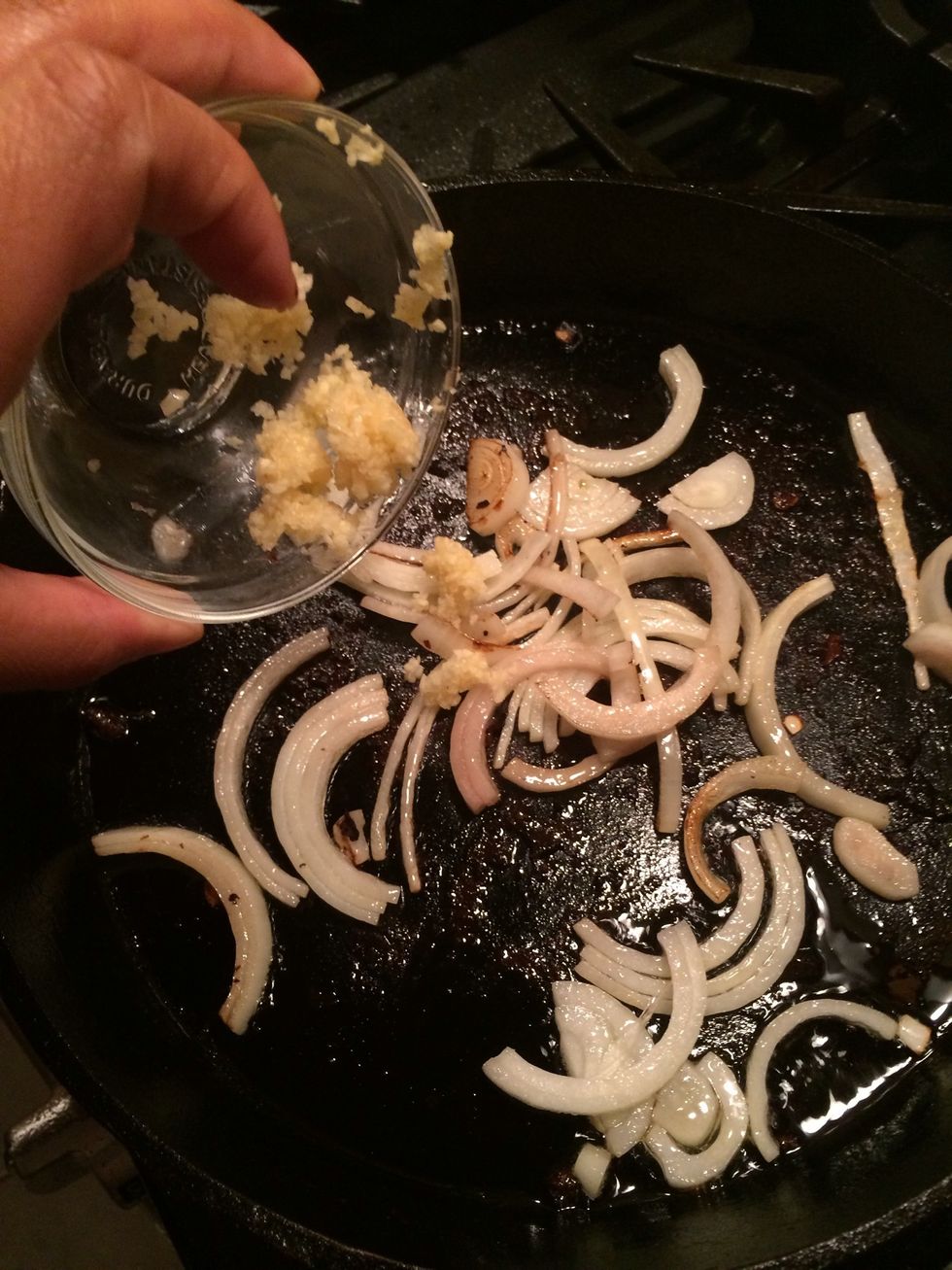 Once the onions have softened a little, add two of the three minced garlics. Cook for a minute or two and remove immediately. Add it to the same bowl you put the mushrooms in.