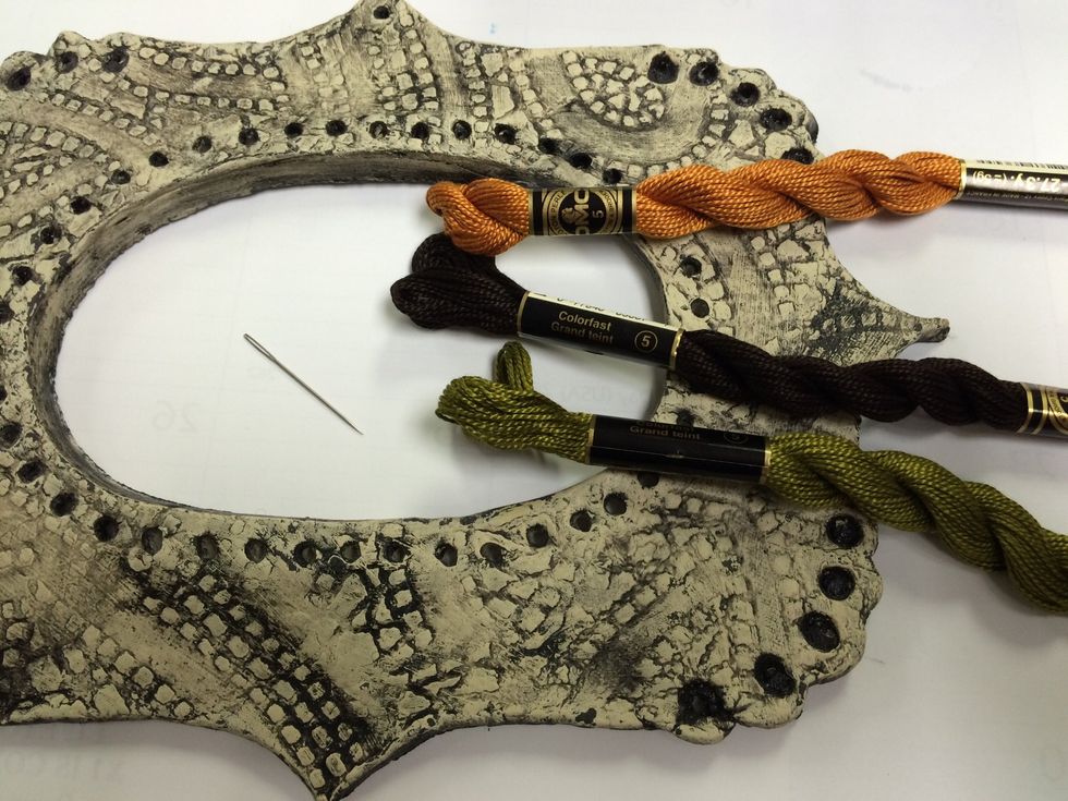 Once the paint is dry you may want to seal it with a clear gloss spray. Collect a few colors of thread or yarn and a needle.