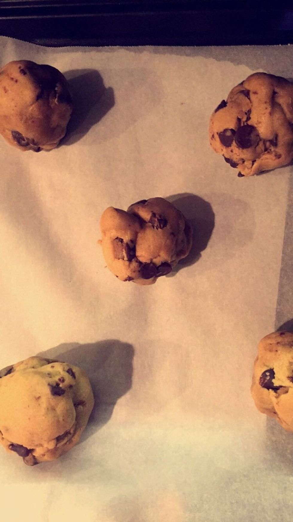 Once the parchment paper is on the tray, the cookie dough balls can be placed on top of it. Make sure the balls are placed far apart from one another.