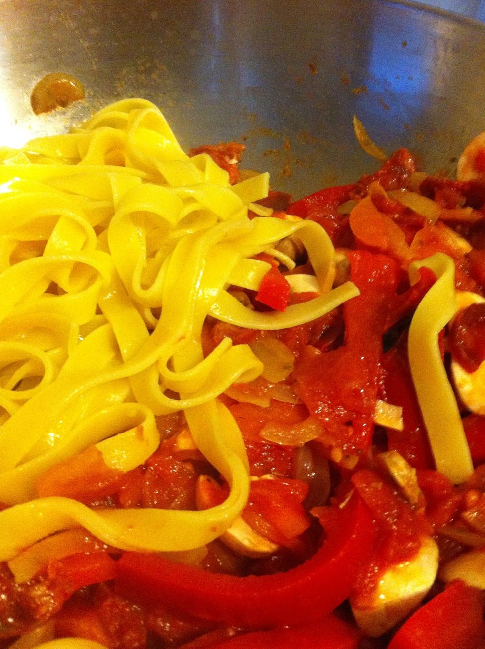 Once the pasta is done, the sauce will be thick and heavy. Drain the pasta and chuck it in. Mix it around...