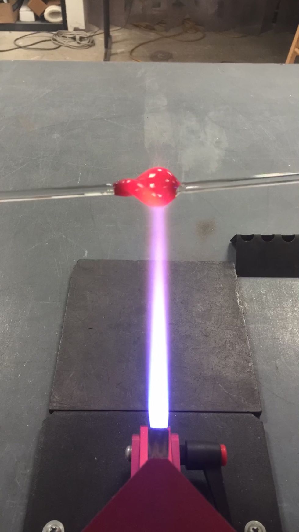 Once the patty is warm, begin letting a twist form by rotating one punty slightly slower than the other. Continue applying gentle heat.