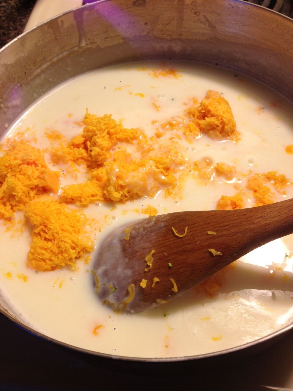 Once the roux has thickened up, remove from heat and stir in half a cup of chicken broth (see my guide on how to make Homemade Chicken Broth!) and 3 cups of cheese.