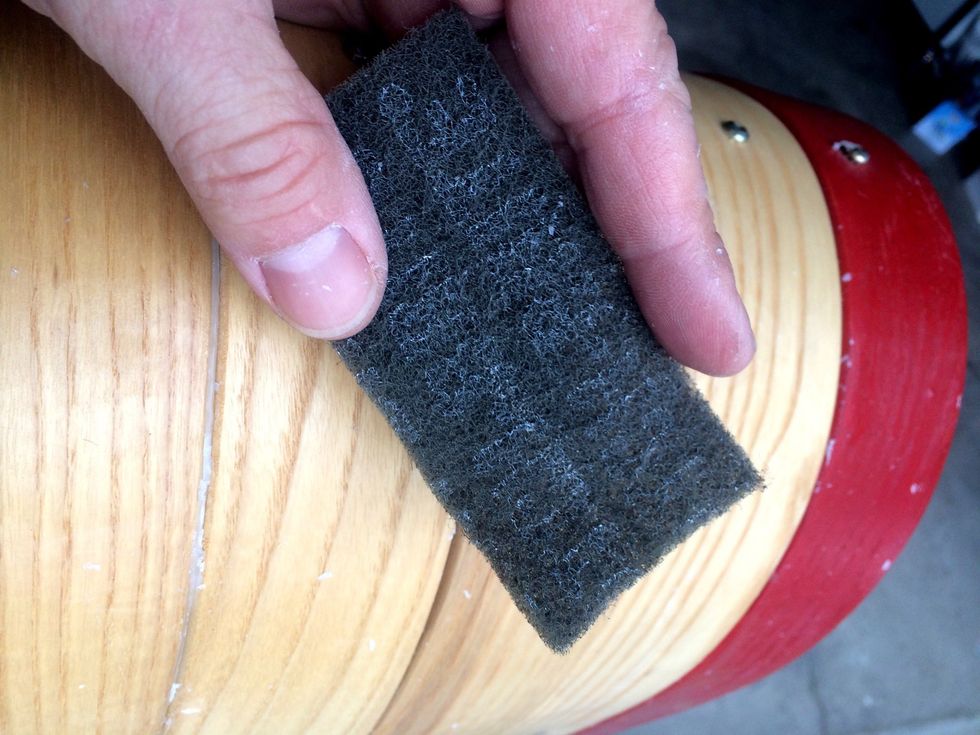 Once the scraping is done take your scotch scrubbing pad & start scrubbing lengthwise the direction of the boards. The point isn't to scrub off the wax but to polish it smooth.