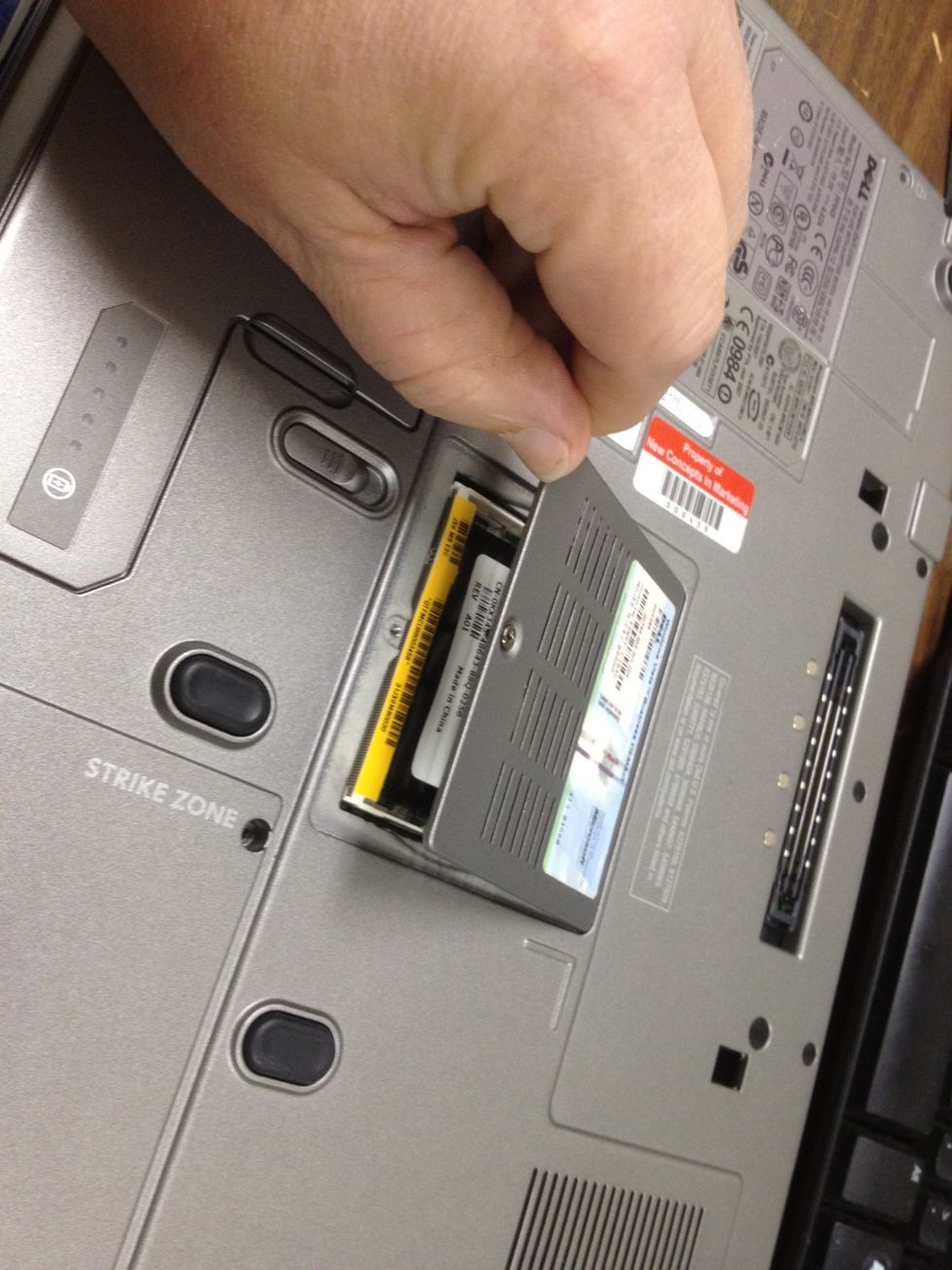 Once the screw(s) is loose, lift and remove the cover for the memory module compartment, being careful not to lose the screw(s).