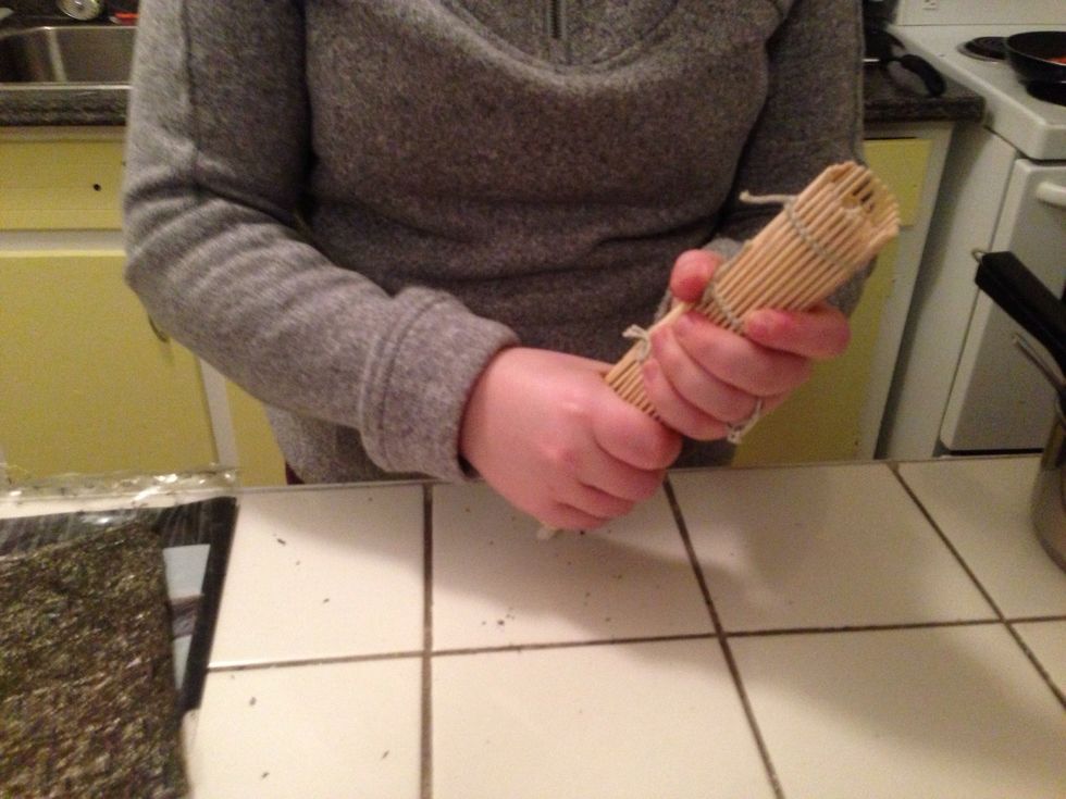 Once the seaweed is rolled up, roll the bamboo around it and squeeze with all your might!