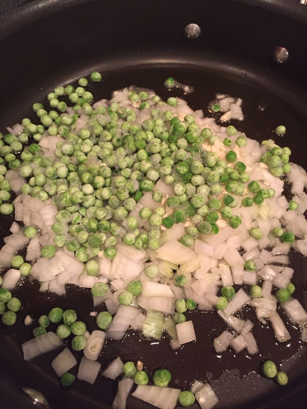 Once the sesame oil heats up, place the onions, peas, and garlic in the pan. Cook until the onions look translucent. Remember to keep stirring.