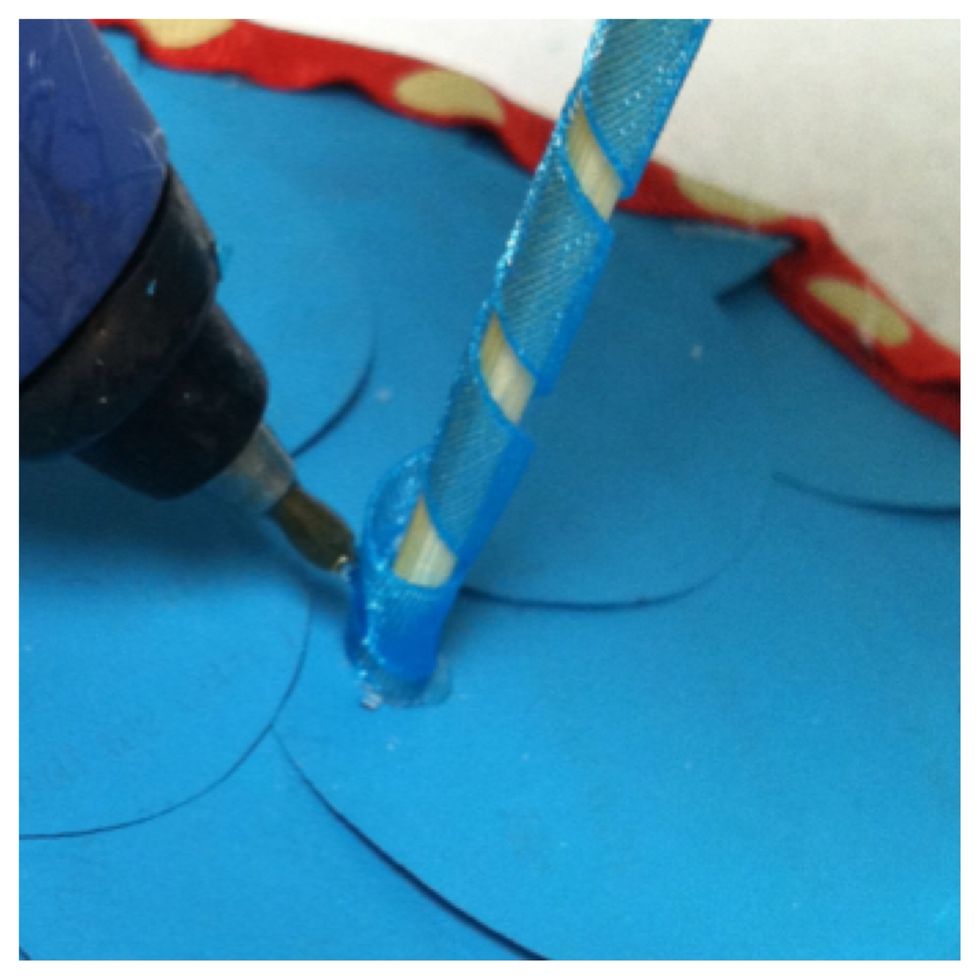 Once the skewer was in place, I applied hot glued to the cone and the base for stability. I then added a ribbon before the glue dried by swirling it from the bottom to the underside of the cone.