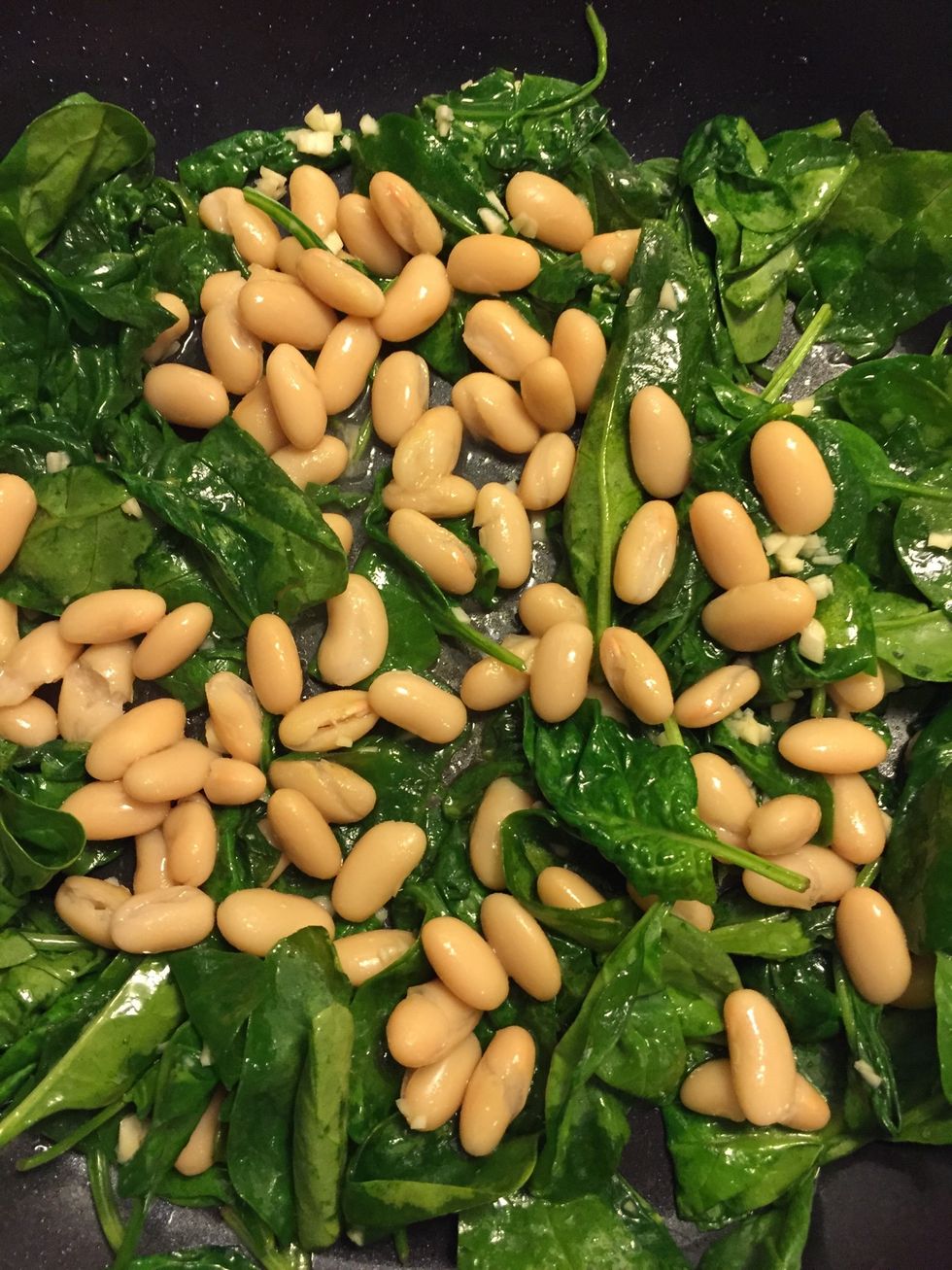 Once the spinach starts to cook down, add in the beans. Season with sea salt & garlic powder.