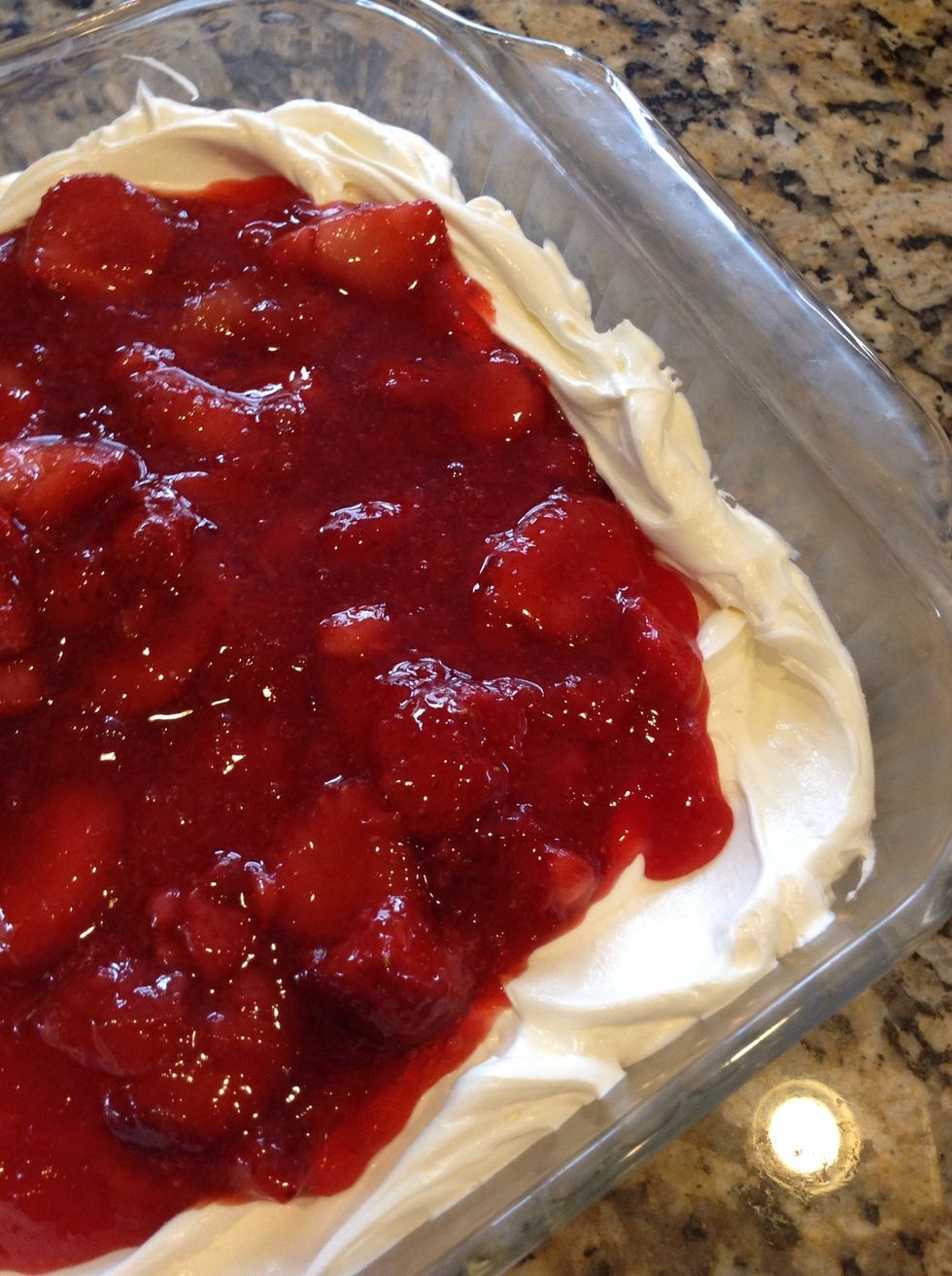 Once the strawberry mixture thickens (takes about an hour)  spread gently on top the whipped topping. Place back in fridge to set up and serve cold.