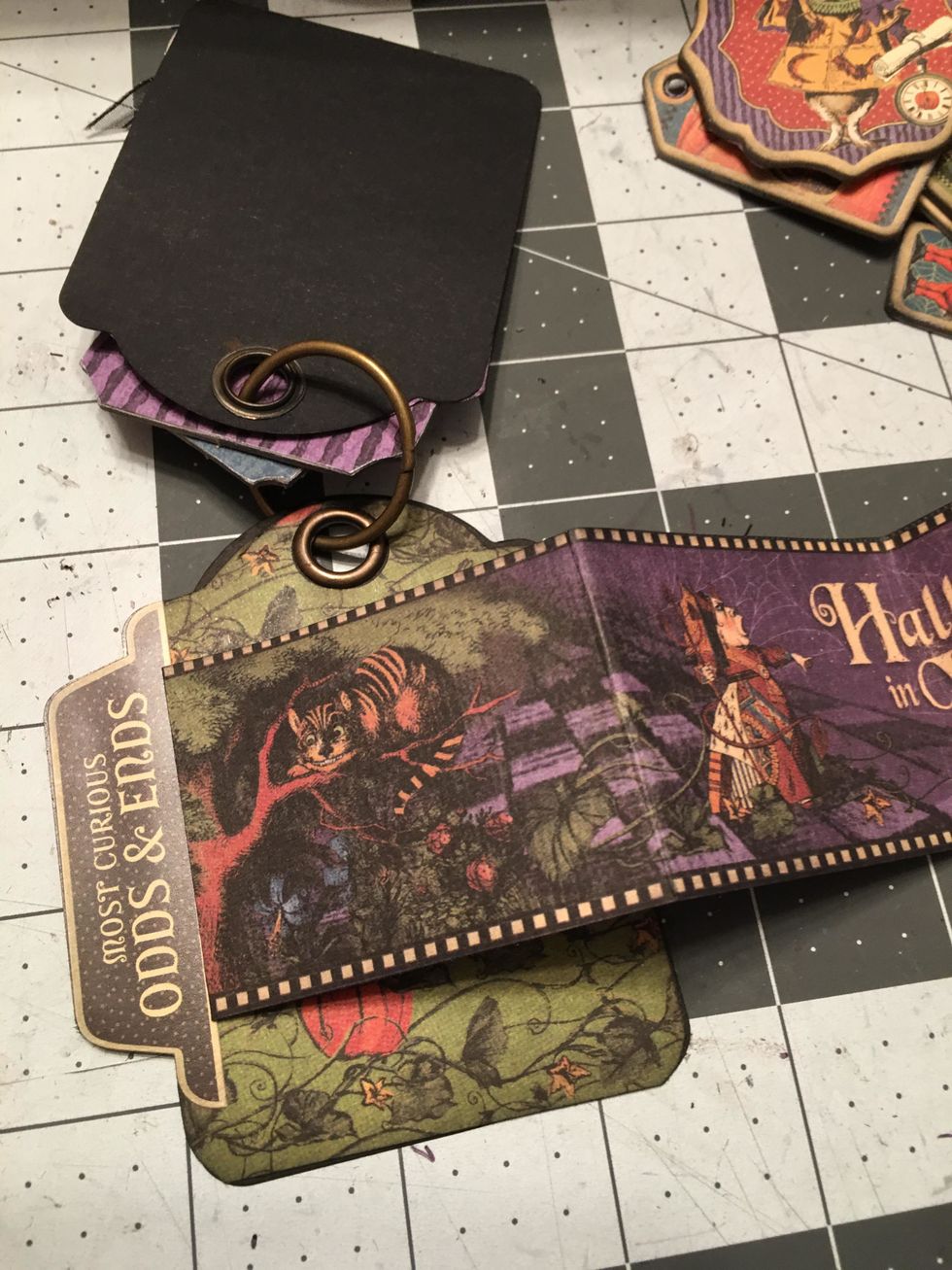 Once the tag is glued down it will look like this and you can then fold up the booklet. You can also add tabs created out of chipboard pieces or stickers from the collection.