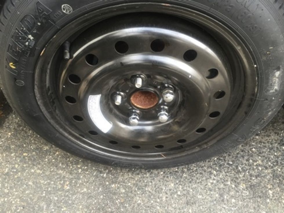 Once the tire is placed on the hub, start placing all lug nuts on screws. Tighten as much as possible with your hands.