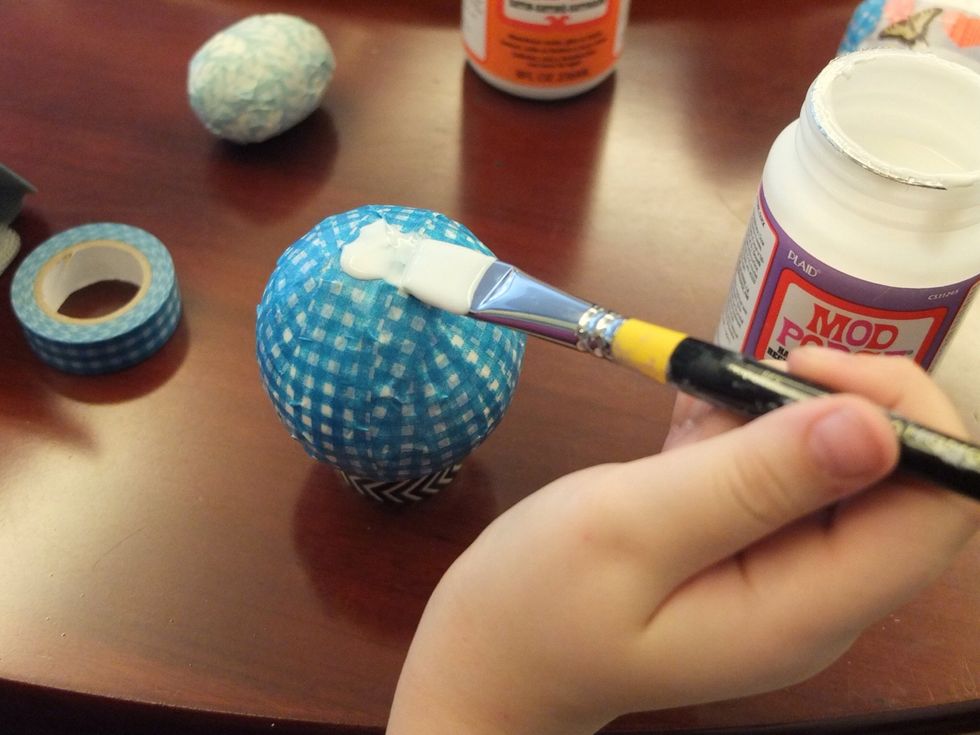 Once the top half is dry turn the ball over to the other side and finish coating the ball with Mod Podge and let dry.