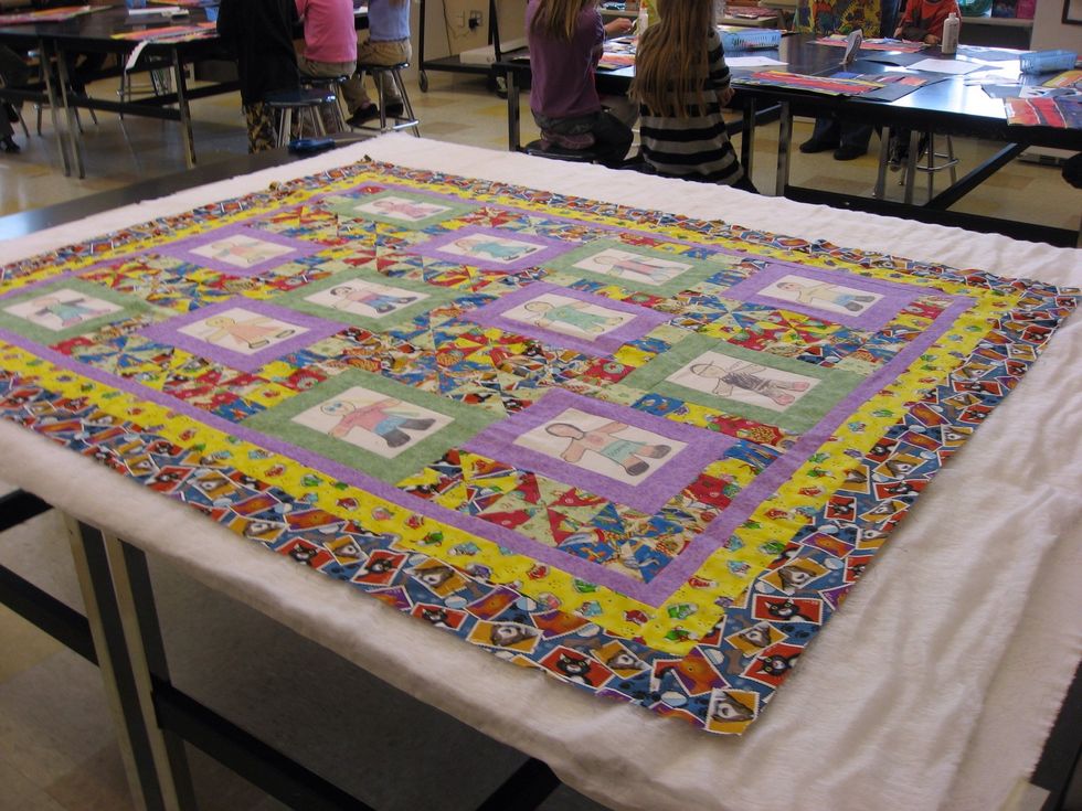 Once the top is done, layer the backing, batting and the top together. Using safety pins, pin the three layers together in preparation for either hand or machine quilting.