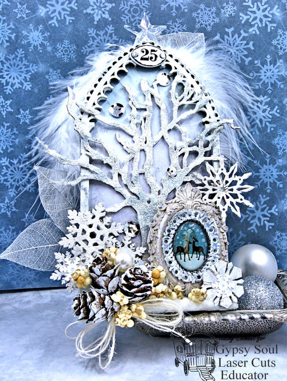 Once the tree is glued in place on the outside edge of the frame, add Glass Bead Glitter gel to bottom of arch to resemble snow.  Add to the top edges of the tree branches as well.  Let dry.