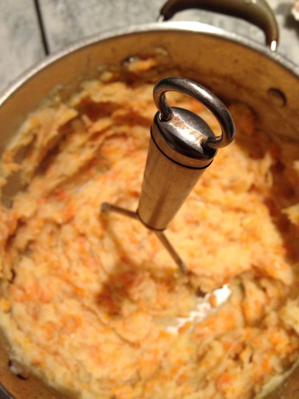 Once the veg is soft, drain off the water, put back in the pot and have at it with a masher. It's gonna be difficult and time consuming to get a smooth mash because of the carrots. But you can try...