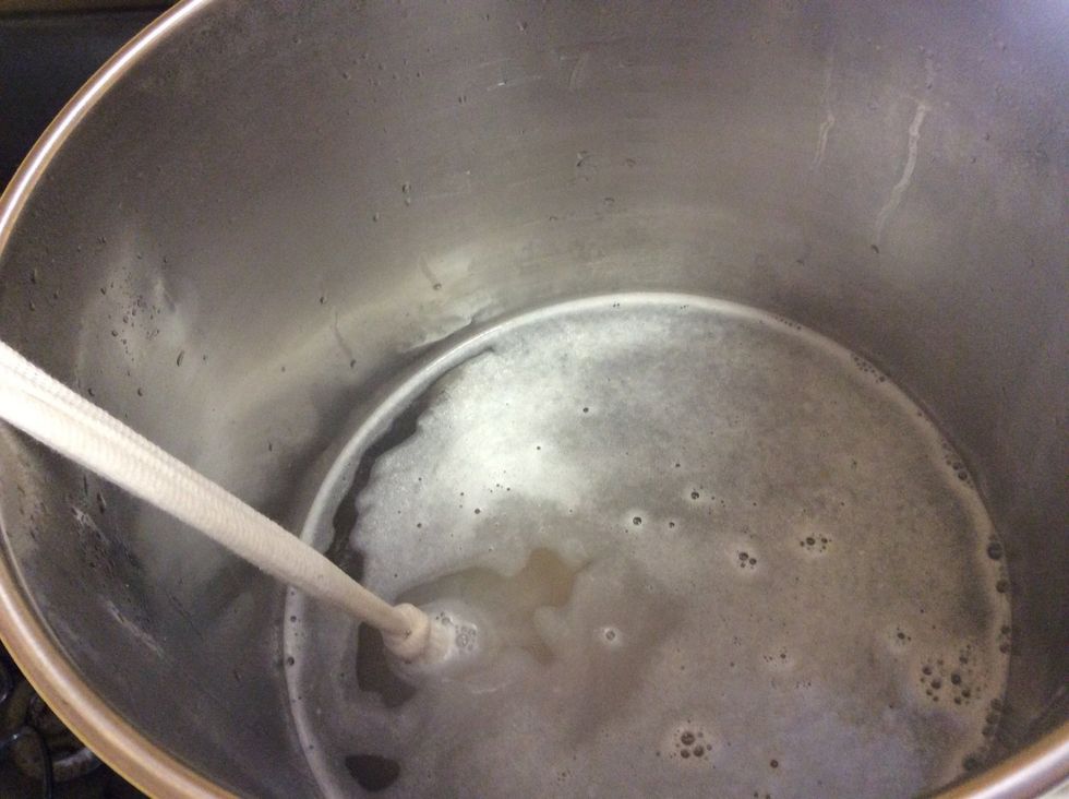 Once the water hits the target steeping temperature, add the bag of grains to the water. I recommend tying off the end (slightly off screen) so you don't have to fish for it later.