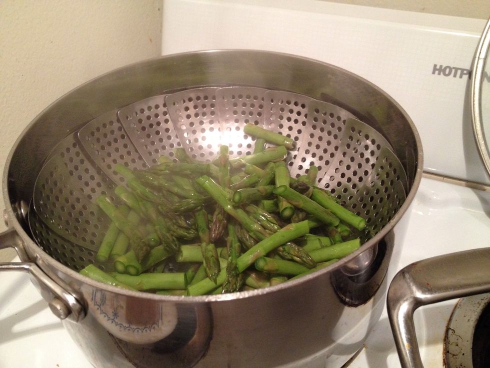 Once the water in the small steaming pot is boiling, add the asparagus and cover and cook for 3-5 minutes.