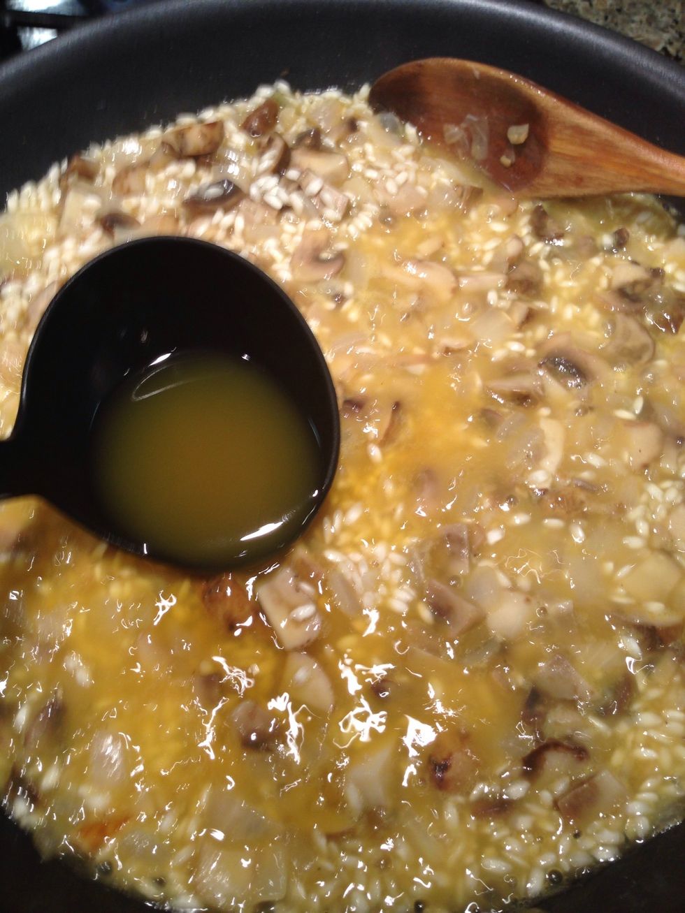 Once the wine has been absorbed, begin ladling in two or three ladles of stock into the rice, stirring frequently. Repeat as liquid is absorbed, generally helps to monitor (stand at the stove...).