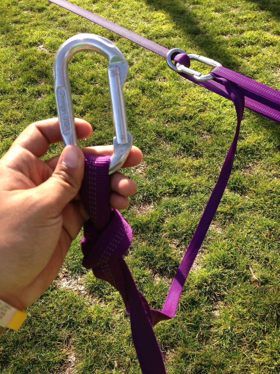 Once tightened to your desired tension, pinch some of the extra webbing and tie a not. Take your fifth carabiner (C5) and connect it as shown.