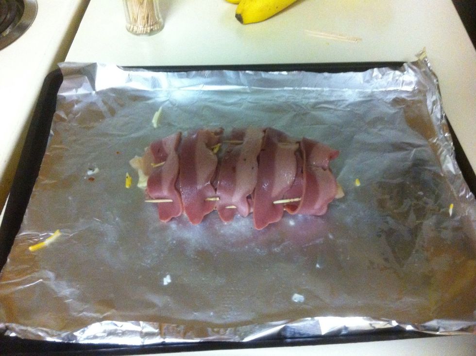 Once wrapped up, weave the toothpicks through the chicken and bacon. Make sure to add toothpicks all around the wrap to keep it wrapped firmly. Count the toothpicks to make it easier takin them out.